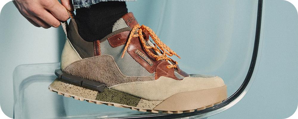 Close-up of a person wearing a Replay multi-textured brown and beige sneaker.